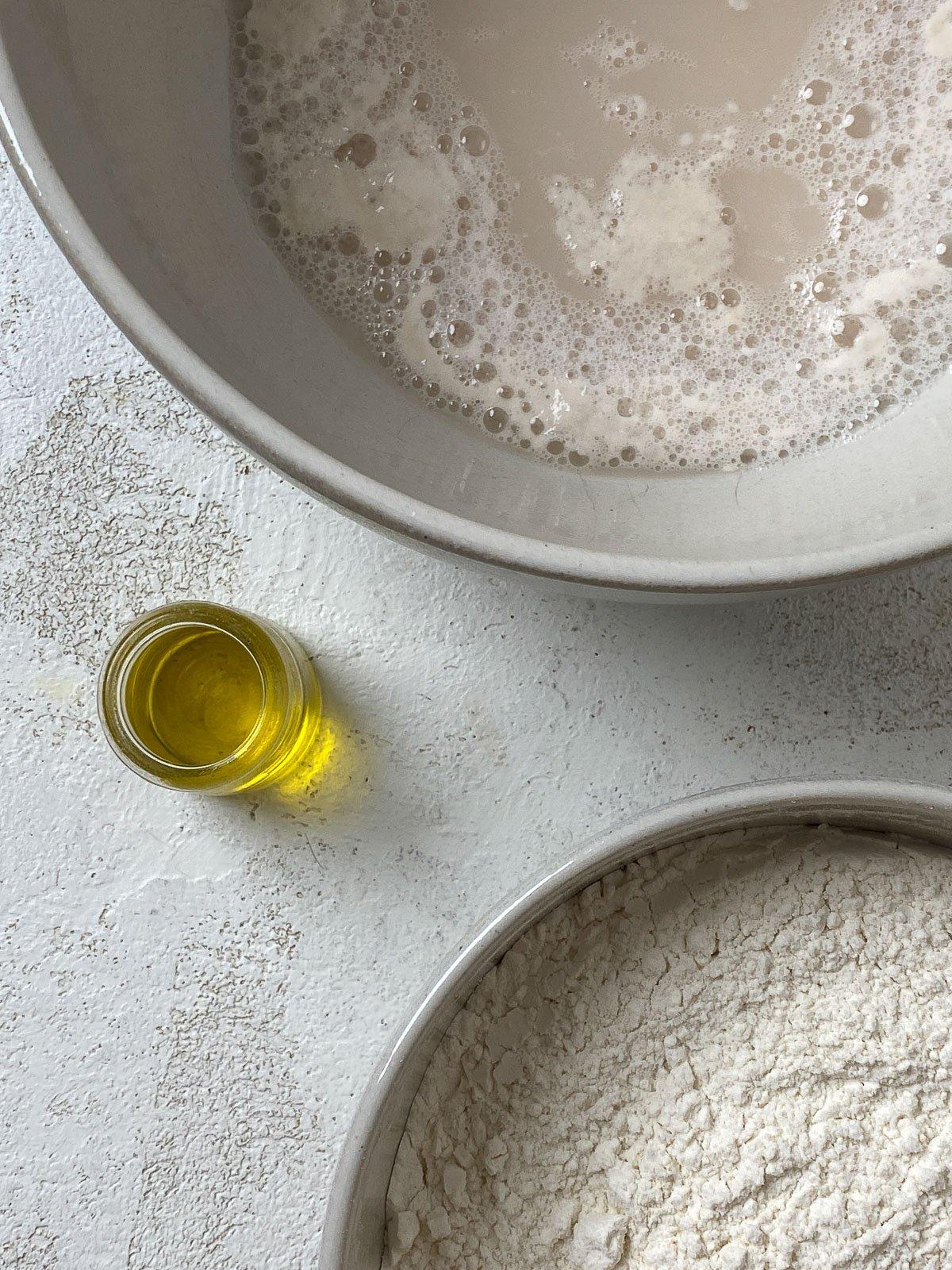 Vegane Pizzaröllchen 5 two bowls alongside olive oil against a white surface