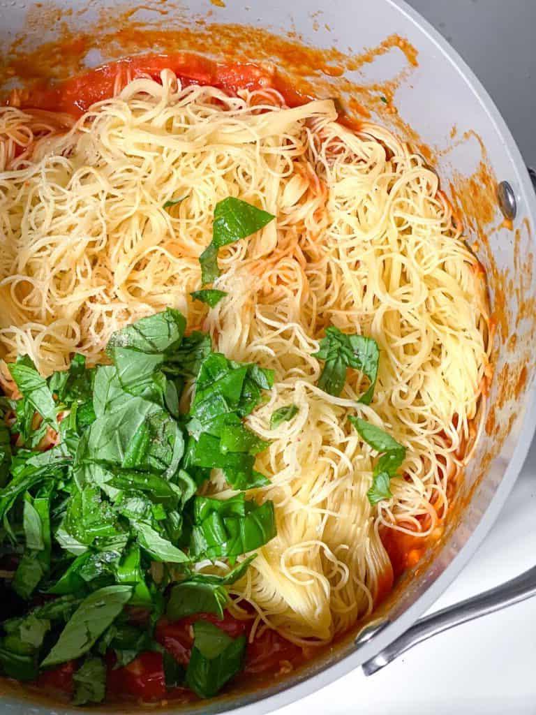 15-Minuten-Kirschtomaten-Basilikum-Pasta 6 Zubereitungsschritt: Die gekochte Pasta wird mit der 15-Minuten-Kirschtomaten-Basilikum-Sauce in der Pfanne vermischt