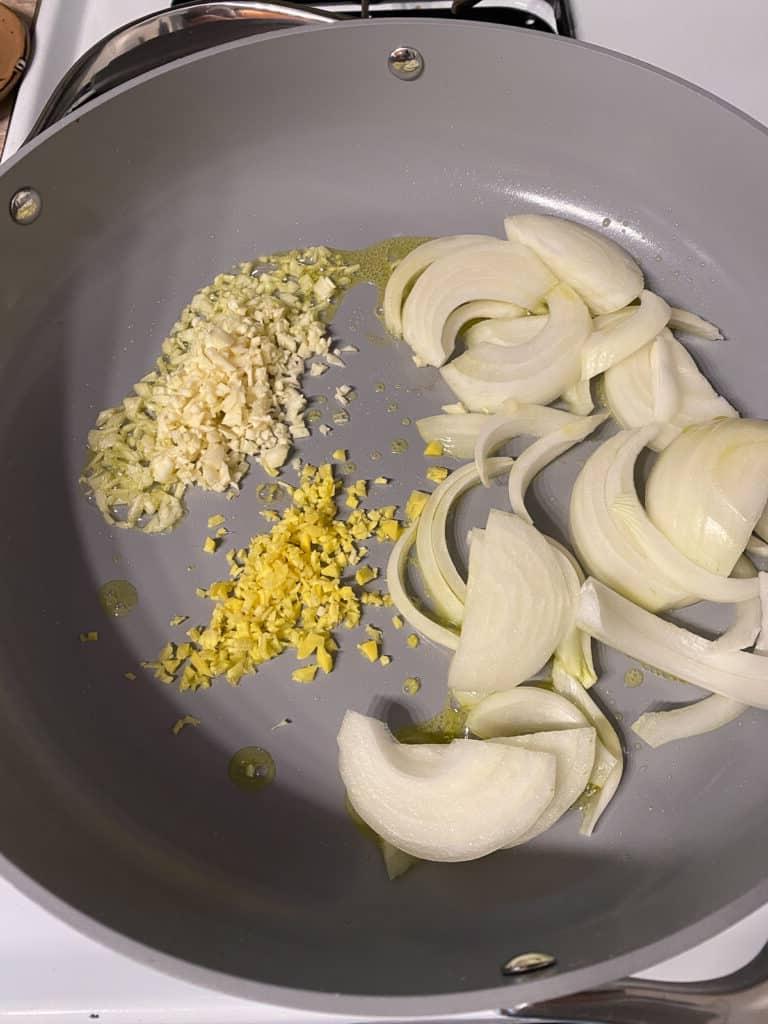 Cremige Reisnudelpfanne 6 Zwiebeln, Ingwer und Knoblauch werden in der Pfanne gekocht