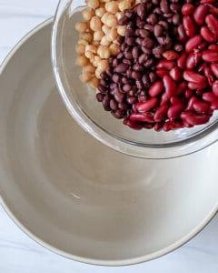Gemischter Bohnensalat 6 process of adding mixed bean salad ingredients into a white bowl
