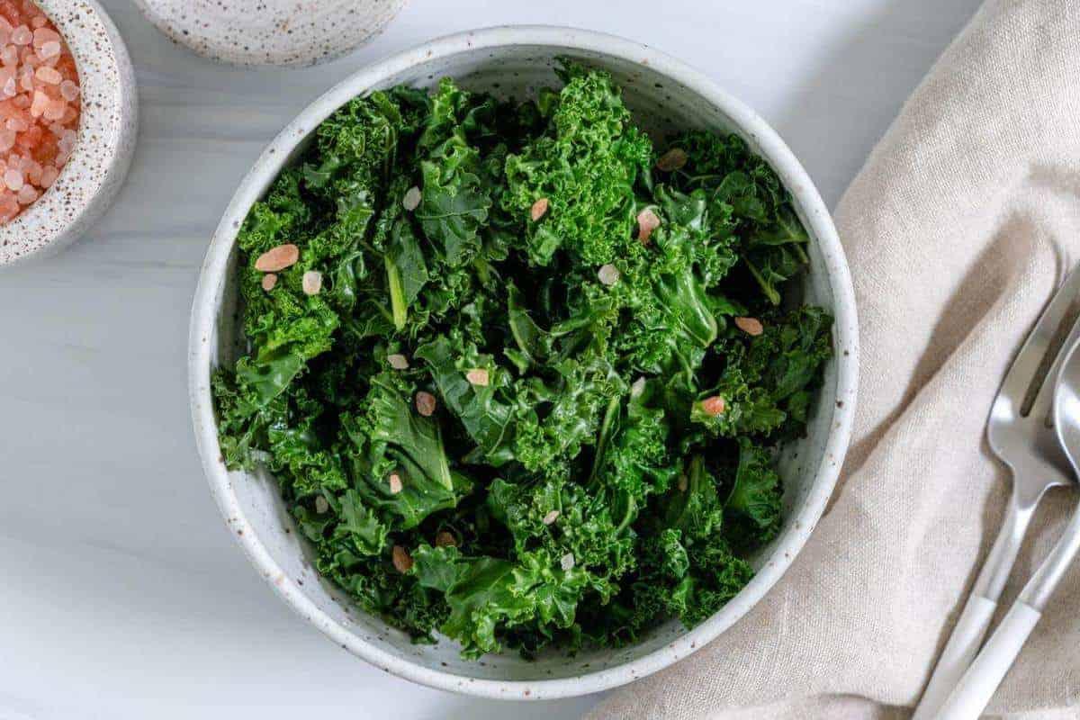 Steamed Curly Kale on a White on a Marble SurfaceBowl