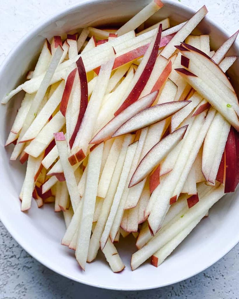 Gehobelter Rosenkohlsalat mit Äpfeln 6 Apfelscheiben in einer Schüssel