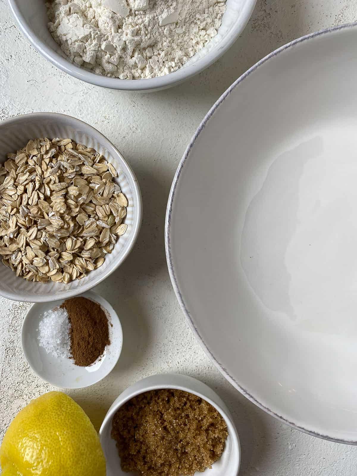 ingredients for Mixed Berry Crumb Pie measured out on a white surface alongside a bowl