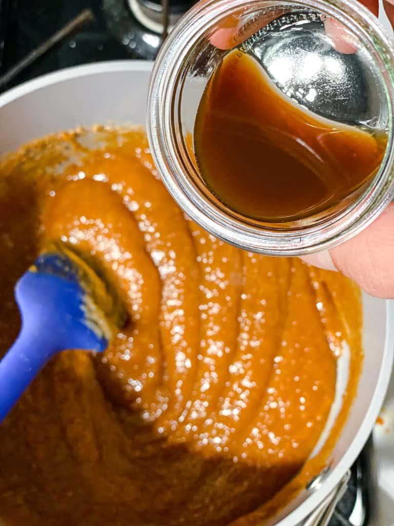 Einfaches Erdnussbutter Granola 6 process shot of adding vanilla extract to peanut butter mixture