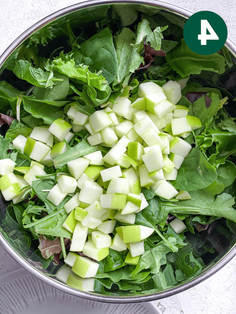 Einfacher Apfel-Pekannuss-Salat mit Preiselbeeren 7 Prozessaufnahme: Salatzutaten in Schüssel geben