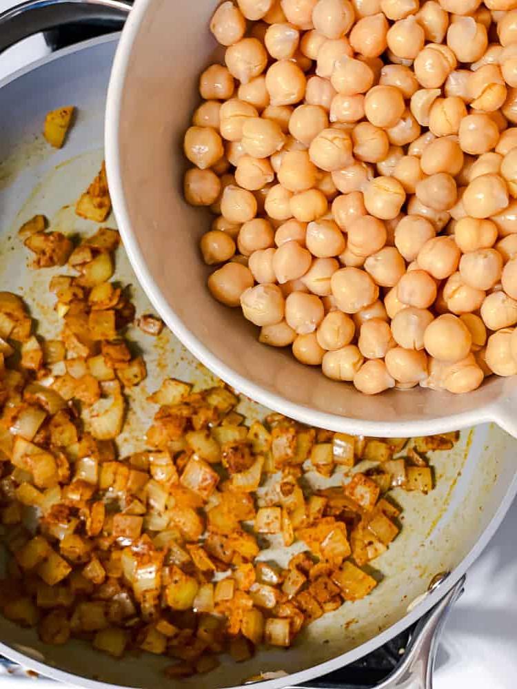 Curry-Kichererbsen 7 Prozessaufnahme: Kichererbsen werden in eine Pfanne mit gekochten Zwiebeln gegeben.