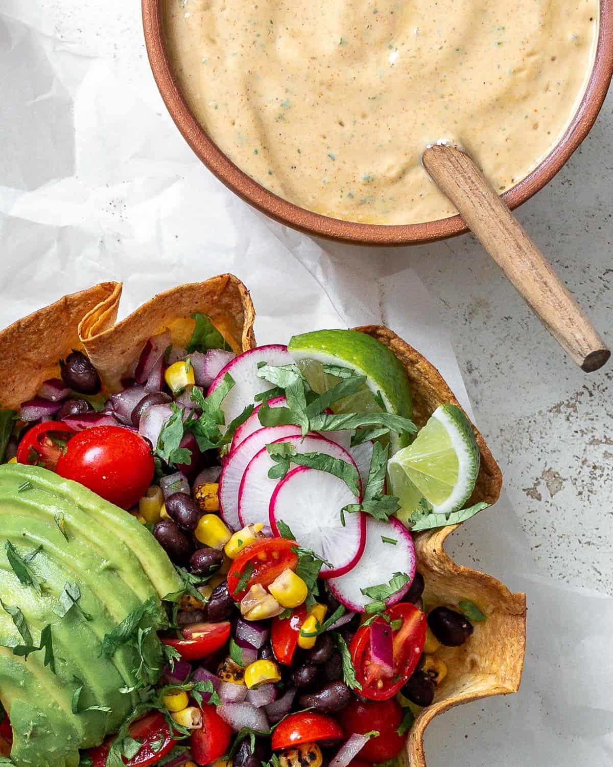 Fertige vegane Chipotle Soße [Taco Salat Dressing] neben einem Taco Salat