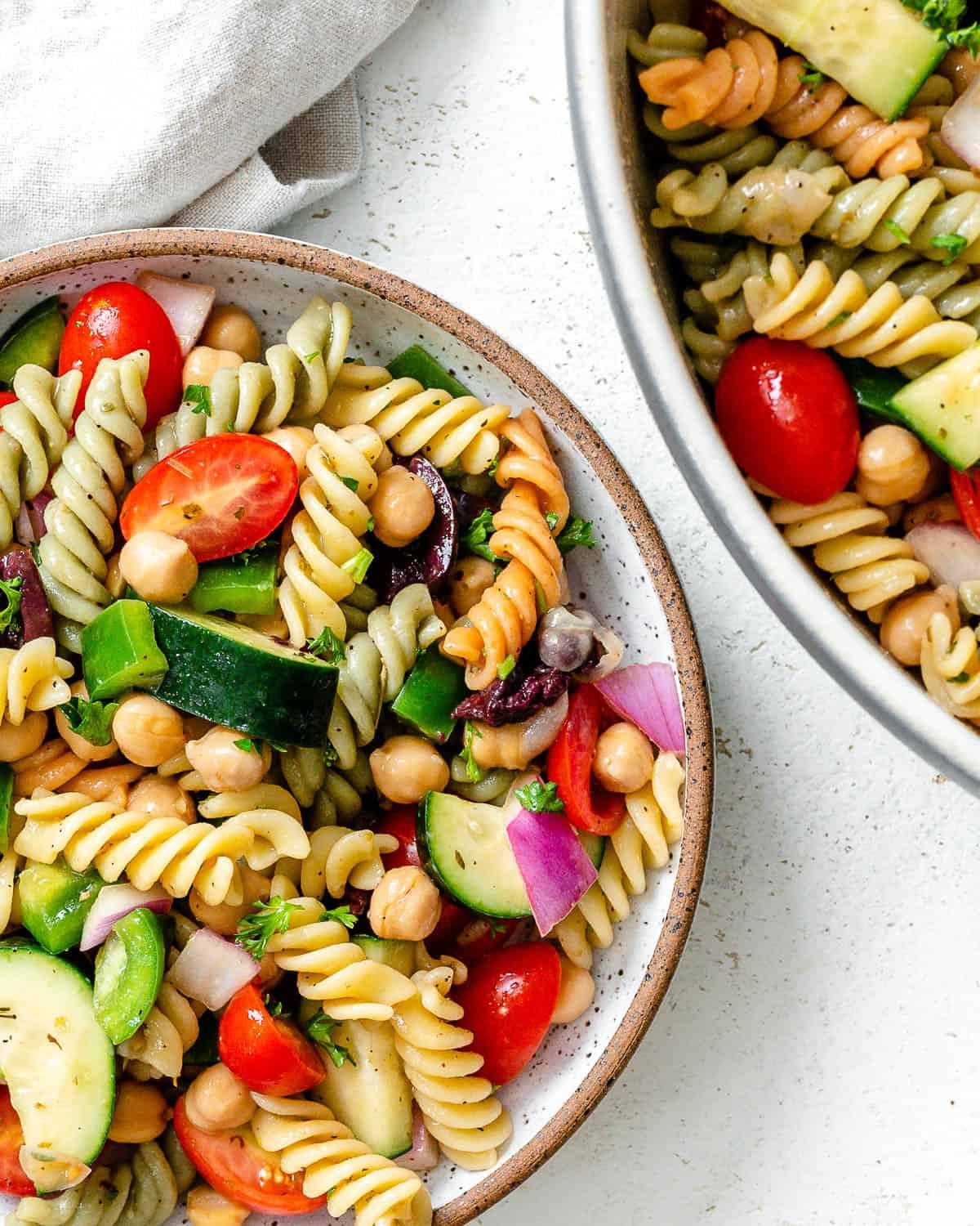 **Mediterraner veganer Nudelsalat** 7 Fertig angerichteter mediterraner veganer Nudelsalat auf weißem Untergrund