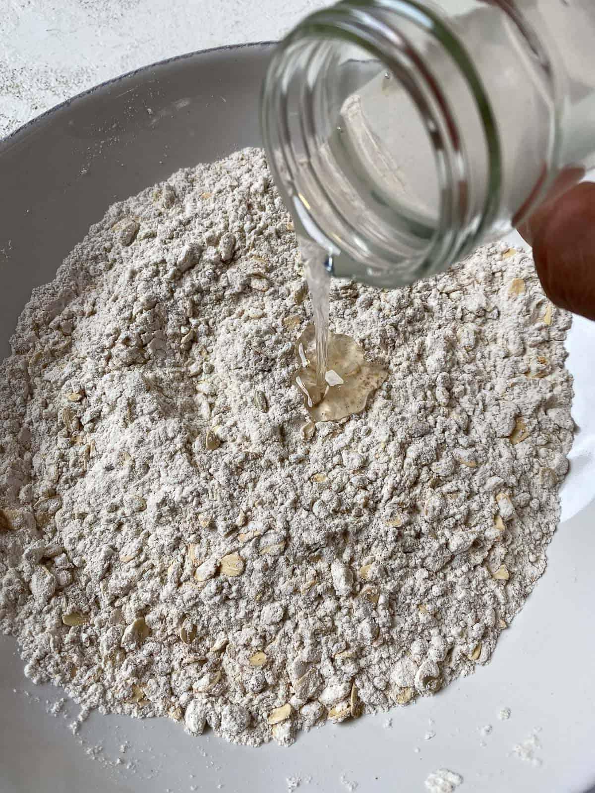 process of adding coconut oil to crumb topping mixture in bowl