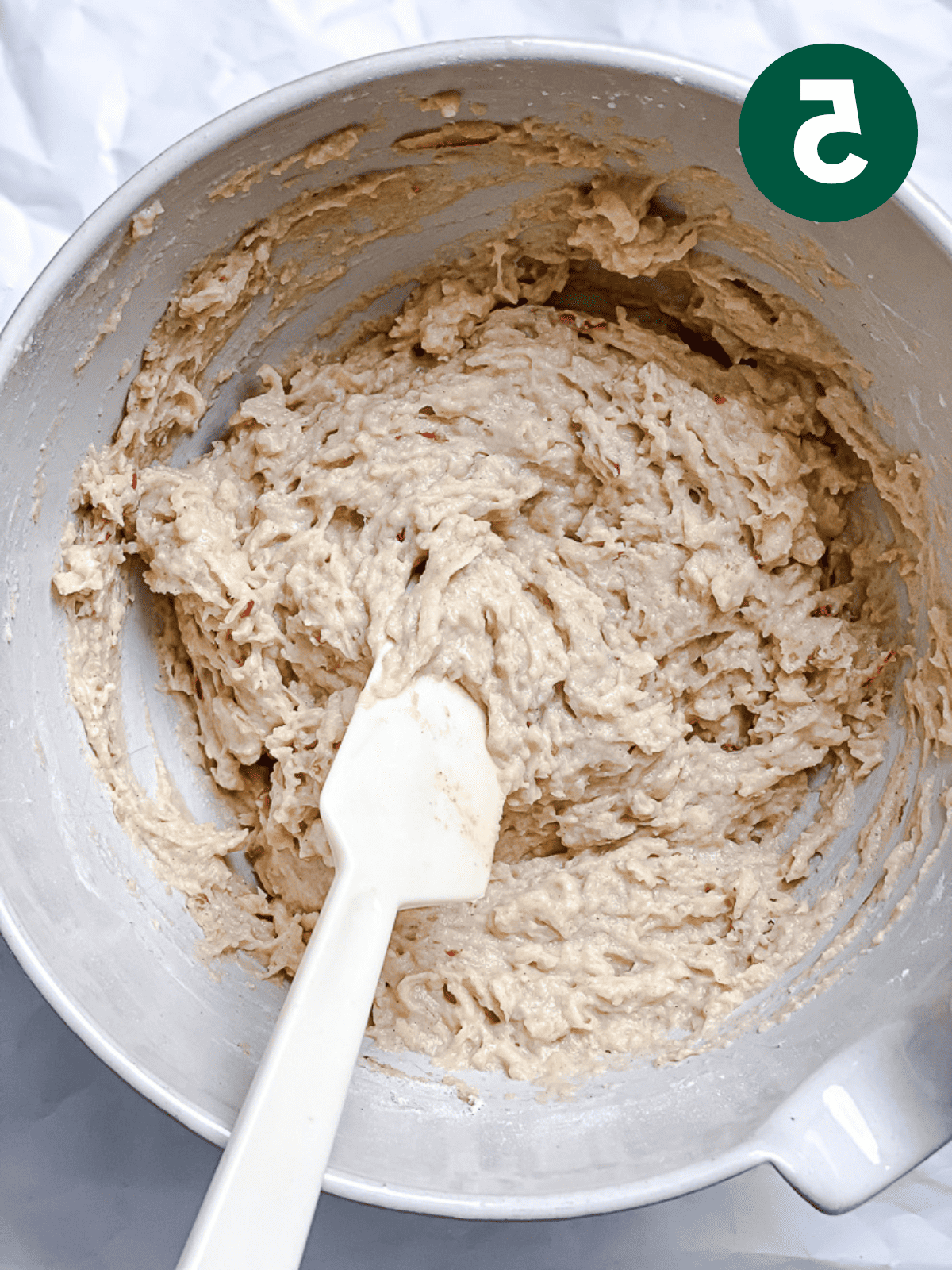 Apfel-Zimt-Brot 8 Apfel-Zimt-Brot Teig in einer großen weißen Schüssel mit einem weißen Spatel verrühren.