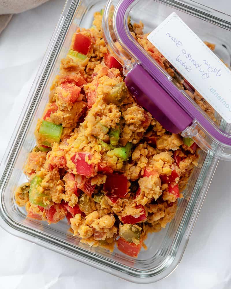 Veganer Kichererbsensalat 8 Veganer Kichererbsensalat in einem Glasbehälter mit Deckel an der Seite beschriftet mit "vegan garbanzo bean salad".