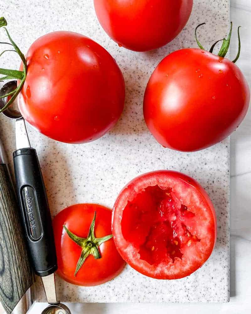 Gefüllte Tomaten 8 Tomate nach dem Aushöhlen neben zwei ganzen Tomaten