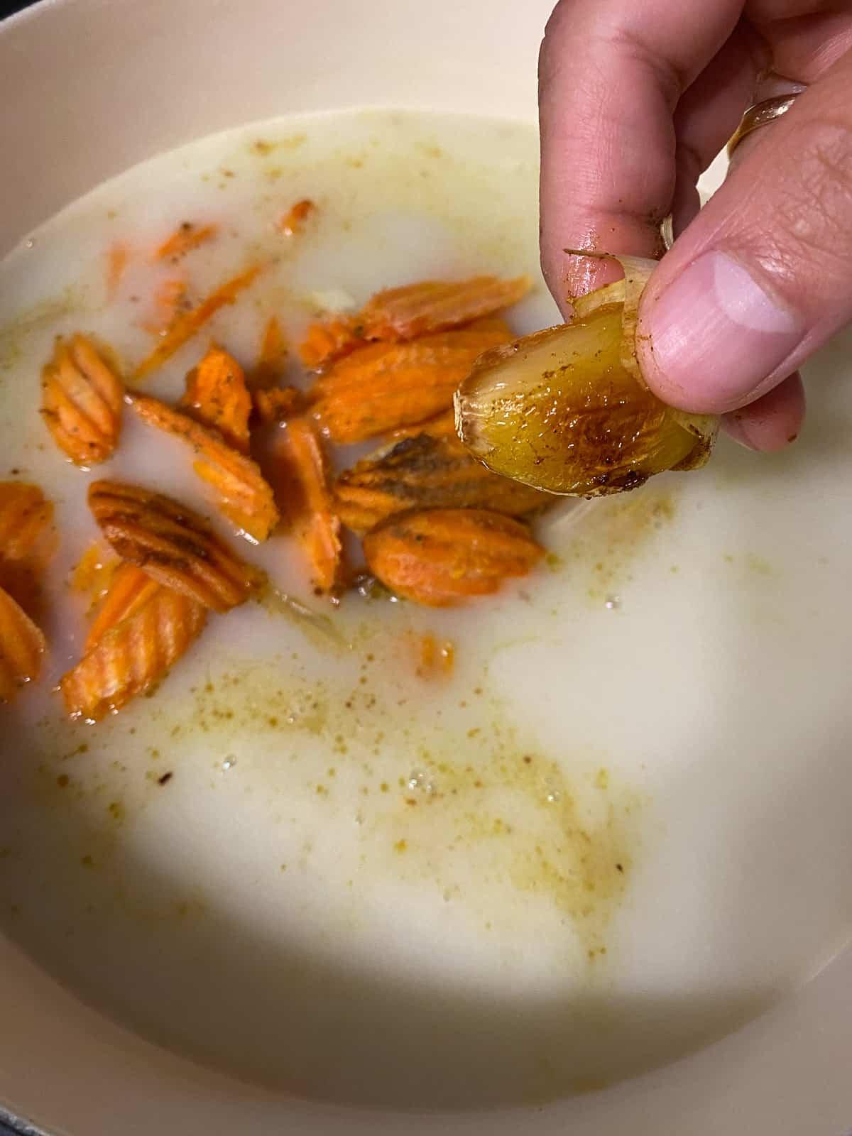 Karotten-Curry-Suppe mit Nudeln 8 Knoblauch aus der Schale in den Topf drücken