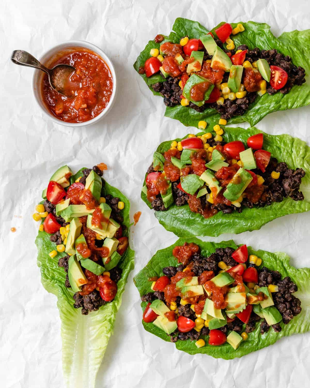 Vegane Schwarze-Bohnen-Salatwickel 8 completed Vegan Black Bean Lettuce Wraps against a white surface