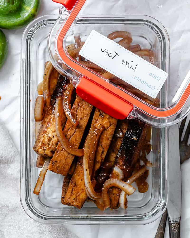 Gebratener Limetten-Tofu 8 Fertiger gebratener Limetten-Soja-Tofu in einem Aufbewahrungsbehälter.