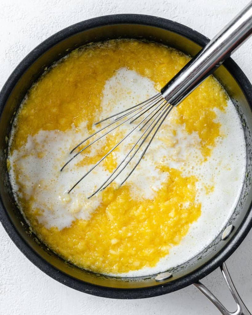 Veganer Kokos-Ananas-Kuchen 8 Arbeitsschritt: Kuchenfüllung in schwarzer Pfanne mischen