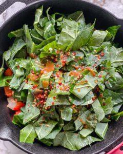 Scharfer Blattkohl 8 process of adding seasonings to vegetables in black pot