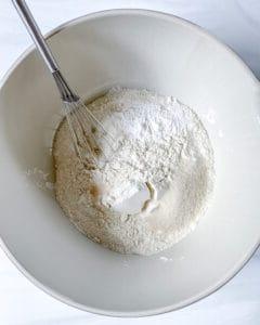 process of vanilla scones ingredients in a white bowl