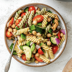 **Mediterraner veganer Nudelsalat** 9 Fertig angerichteter mediterraner veganer Nudelsalat auf weißem Untergrund