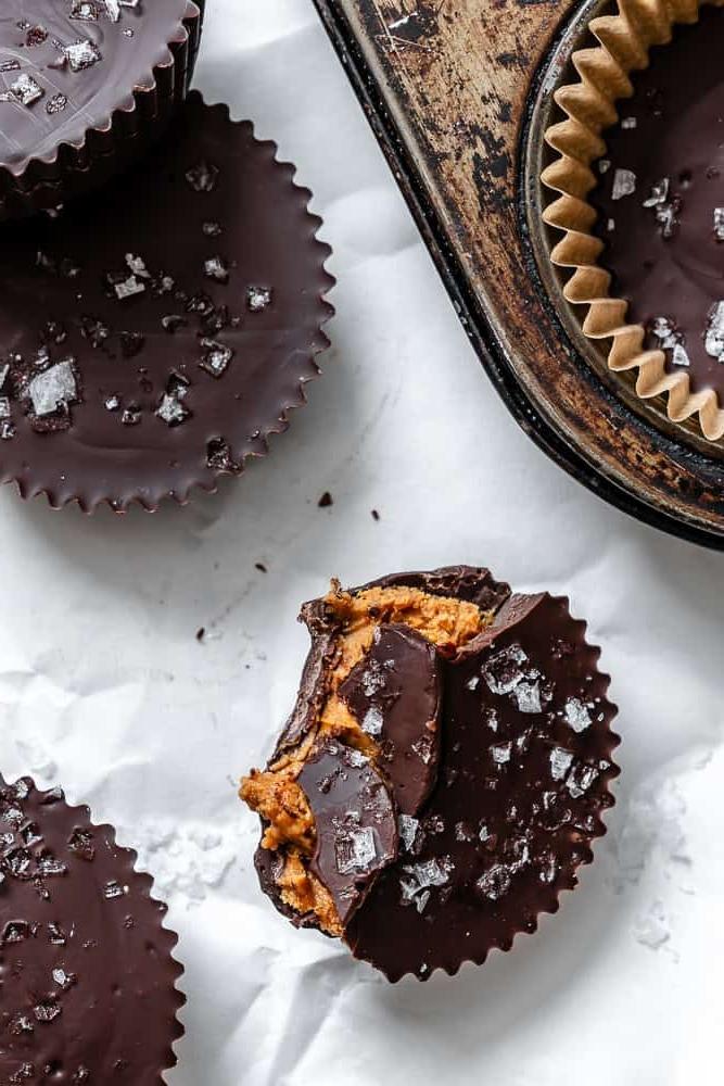 Fertige vegane Erdnussbutter-Cups auf einer weißen Oberfläche.