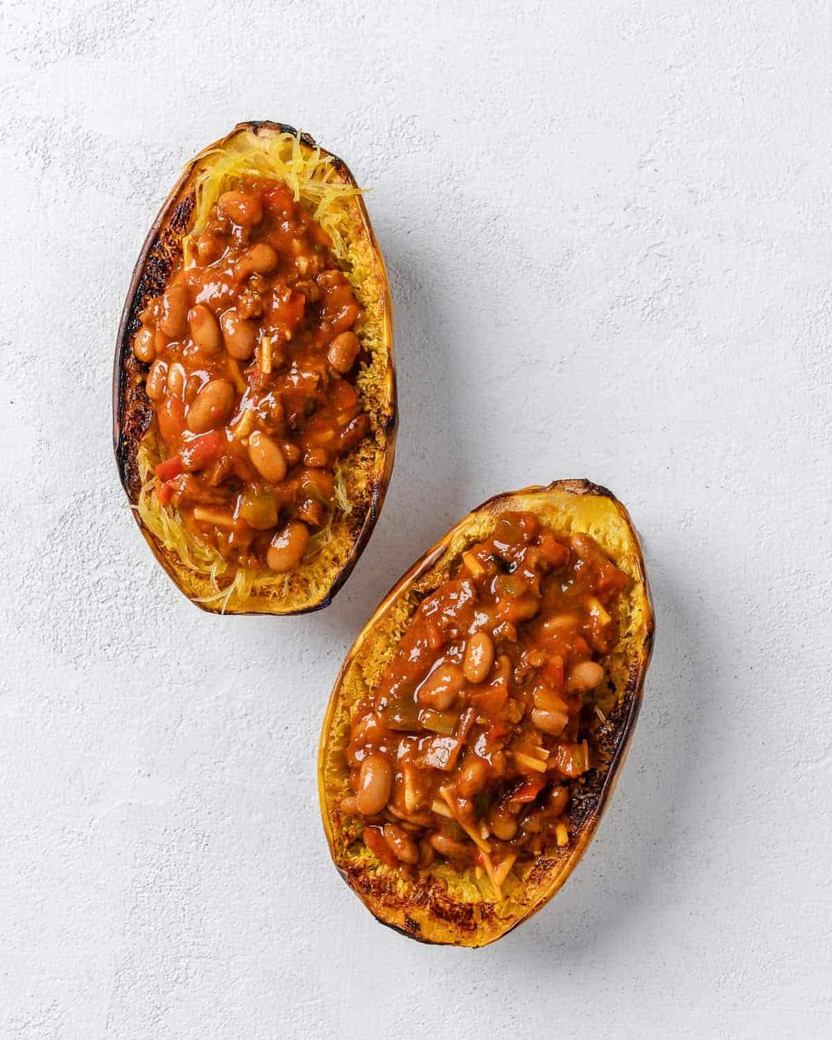 Chili-Käse-gefüllter Spaghettikürbis 9 completed stuffed spaghetti squash with chili against white background
