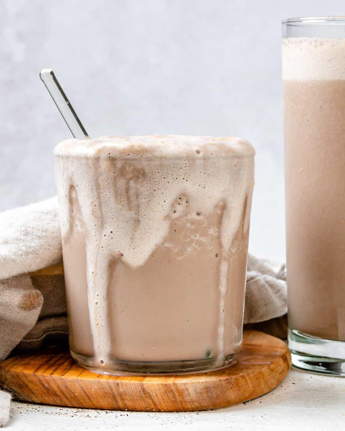 Fertiger Zimt-Hanfsamen-Kaffee-Shake in zwei Gläsern auf hellem Untergrund
