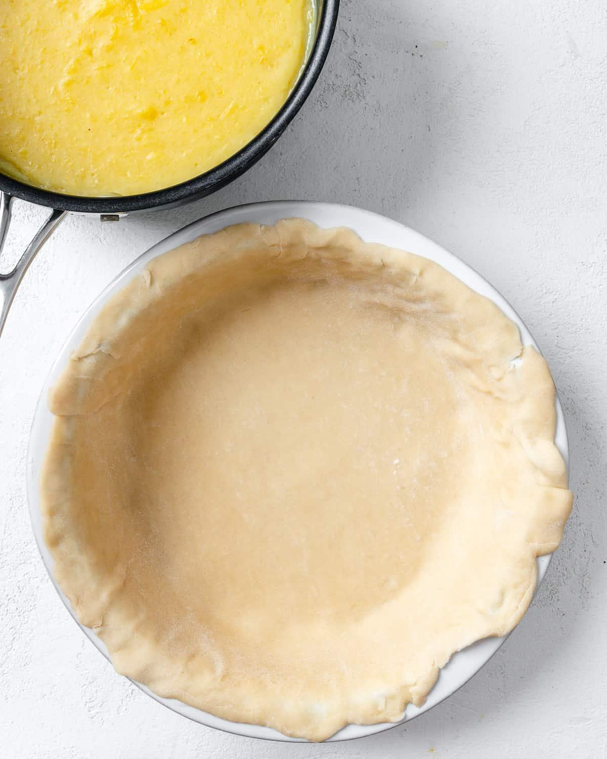 Veganer Kokos-Ananas-Kuchen 9 Arbeitsschritt: Tortenboden in Kuchenform vor weißem Hintergrund
