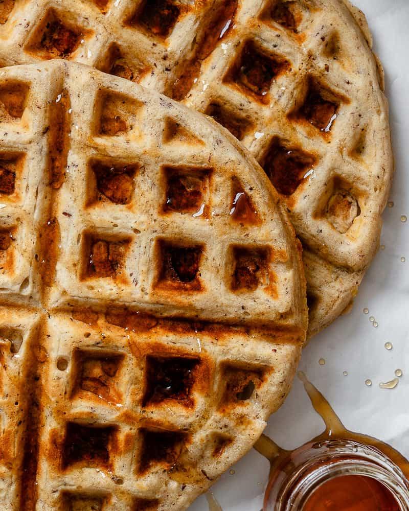 Vegane Waffeln 9 Nahaufnahme von perfekt gebackenen veganen Waffeln mit einem großzügigen Guss Ahornsirup.