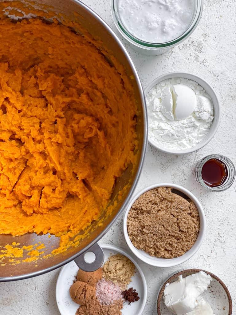 Veganer Süßkartoffelkuchen 9 Zutaten für veganen Süßkartoffel-Kuchen, auf weißem Untergrund ausgelegt