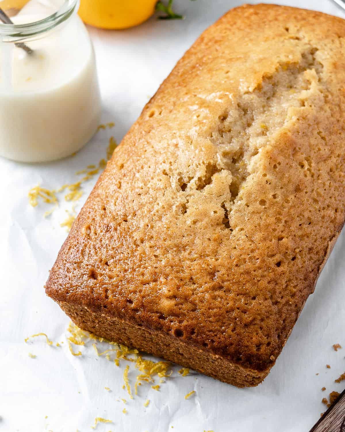 Veganer Zitronen-Kastenkuchen 9 Fertig gebackener Zitronenkuchen vor weißem Hintergrund, geschnitten und bereit zum Anrichten