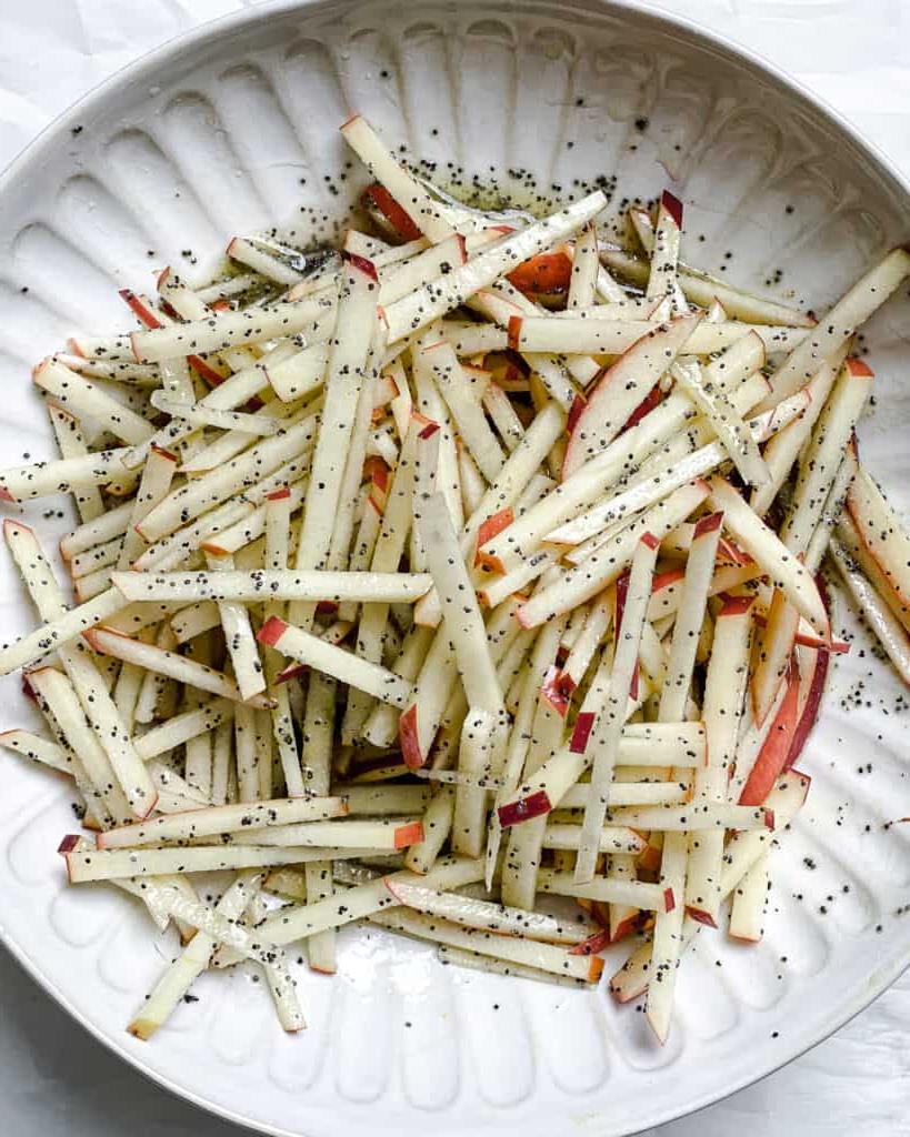 Gehobelter Rosenkohlsalat mit Äpfeln 9 Prozessaufnahme des Vermischens von Äpfeln und Dressing