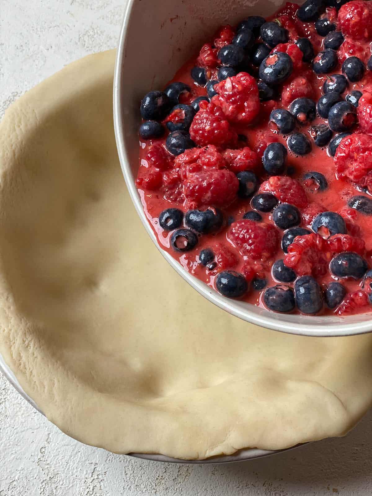 process of adding berry ingredient mixture to pie crust