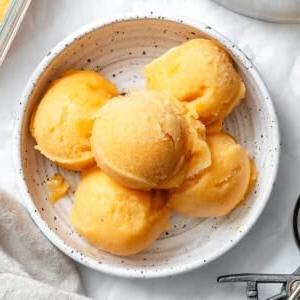 **Pfirsich Sorbet** 10 5 Kugeln Pfirsich Sorbet in einer weißen Schale.