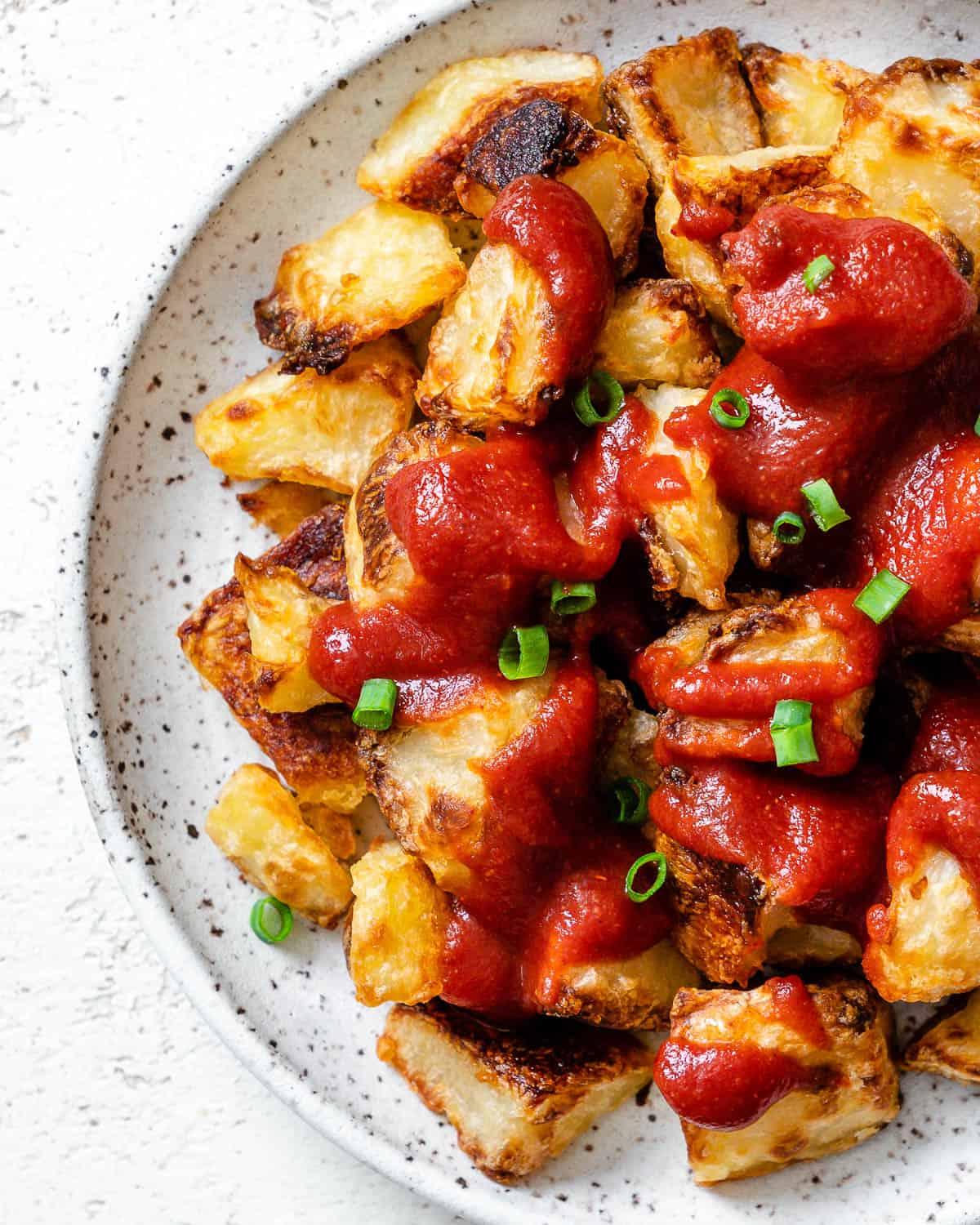 Fertige Patatas Bravas auf einem weißen Teller angerichtet