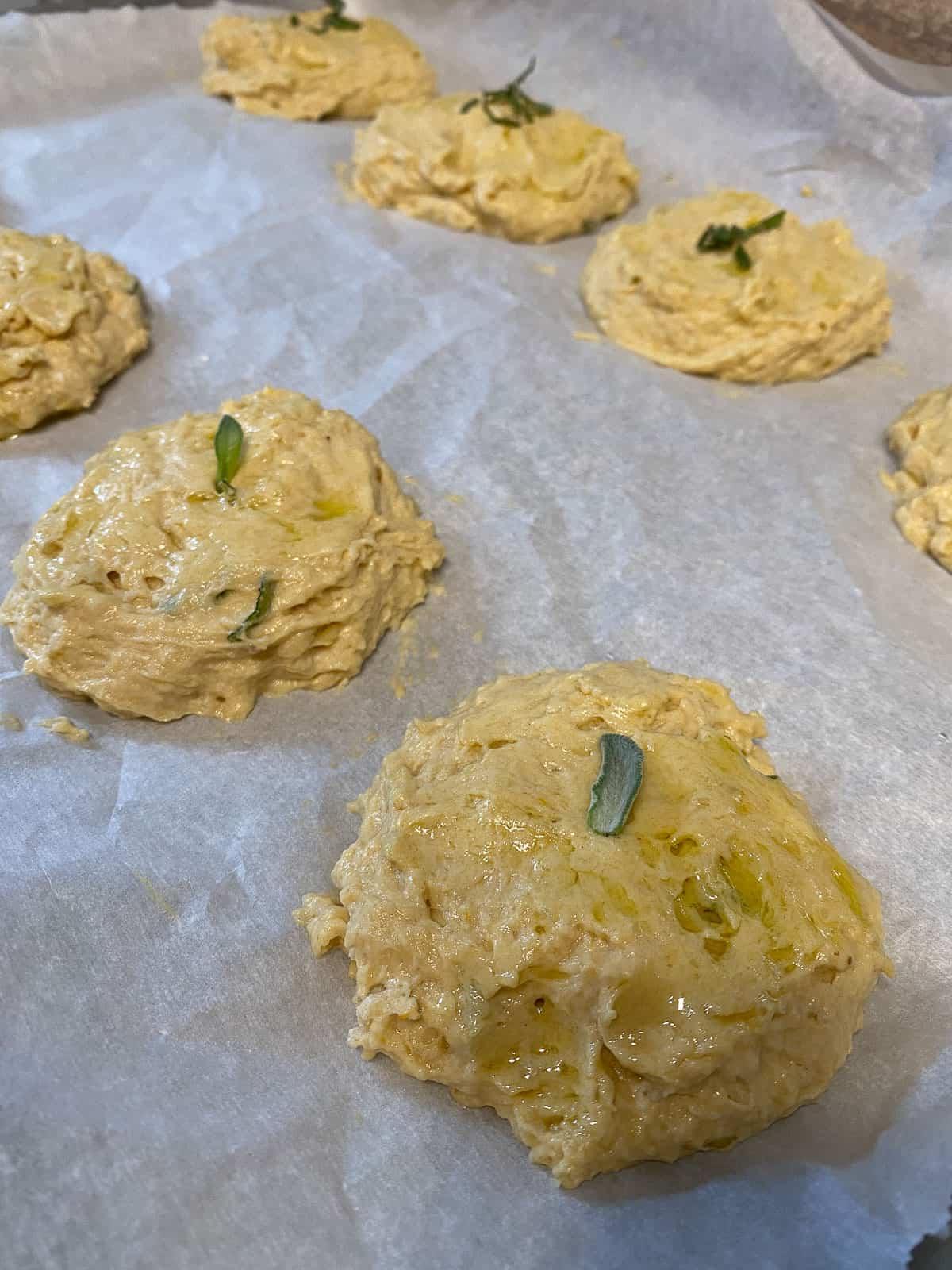Butternusskürbis-Salbei-Gebäck 10 Butternut-Kürbis-Salbei-Biscuits, auf Backpapier ausgelegt.
