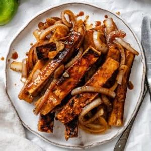 Gebratener Limetten-Tofu 10 Fertiger gebratener Limetten-Soja-Tofu auf einem Teller