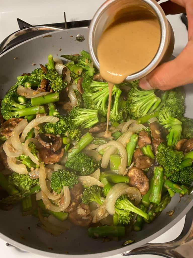 Cremige Reisnudelpfanne 10 Tahini wird in die Pfanne gegeben