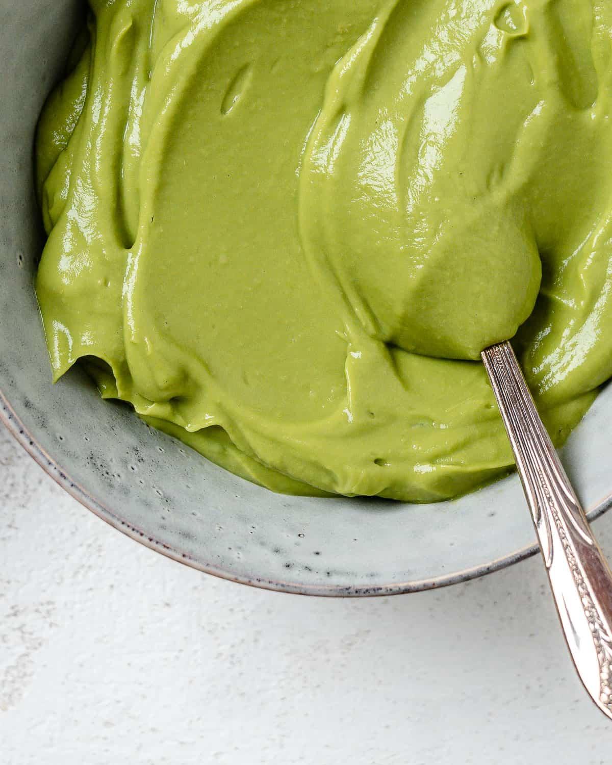 Einfacher Avocado-Aufstrich 10 Fertiger cremiger Avocado-Aufstrich in einer Schale vor hellem Hintergrund