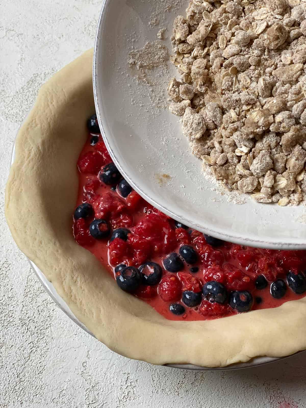 process of adding crumb topping on top of berry mixture