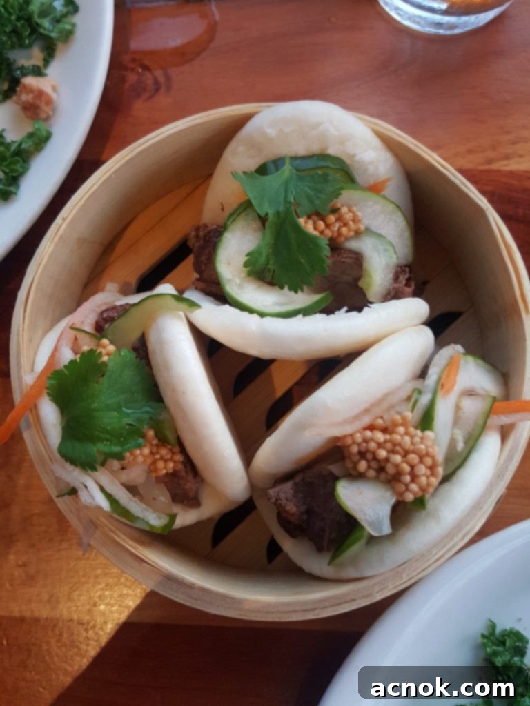 Close-up of Keoki's Paradise Kalbi Beef Bao, a delicious appetizer with hoisin-ginger braised short rib and fresh toppings.