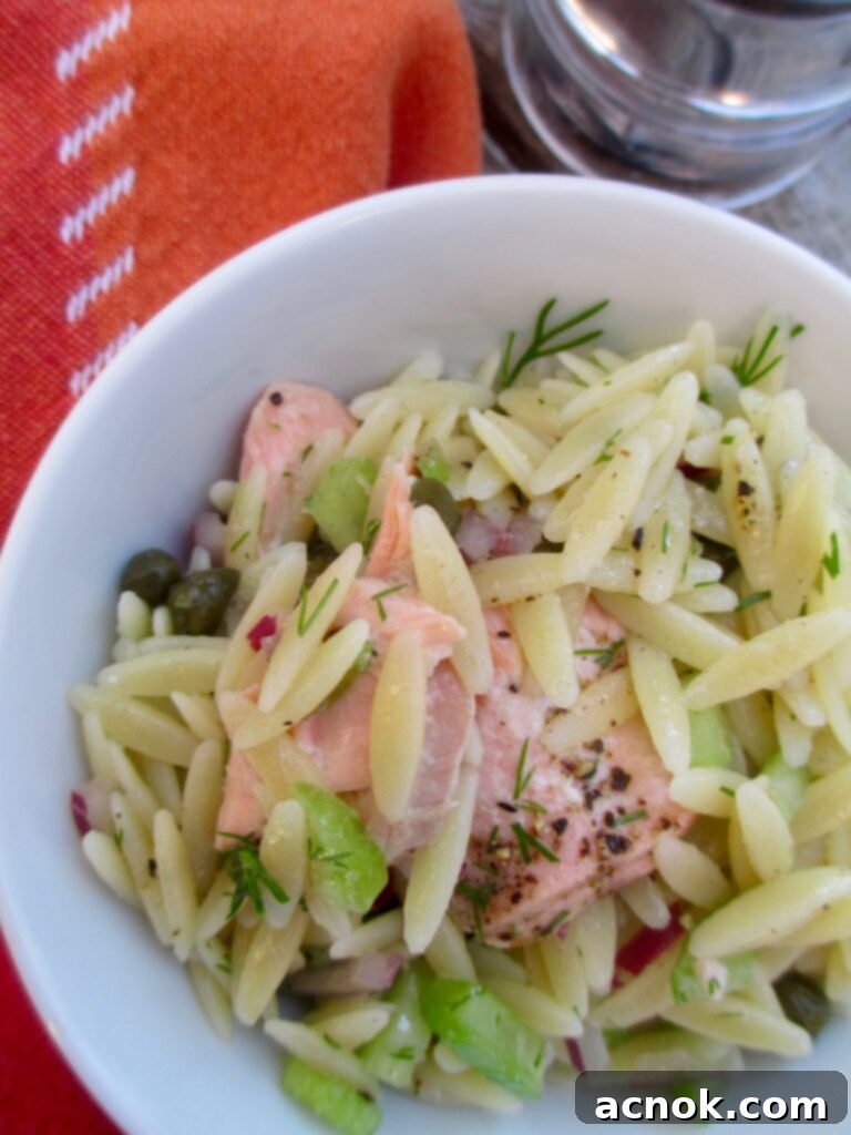Delicious and healthy Salmon Caper Orzo Salad served in a bowl, perfect for lunch or brunch.