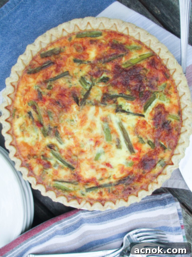 Lobster Asparagus and Gruyere Quiche - A beautifully baked quiche slice with visible lobster pieces and asparagus.