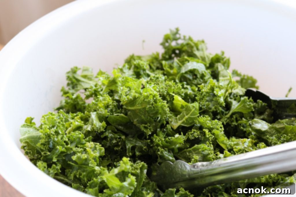 kale in white plastic bowl with tongs 