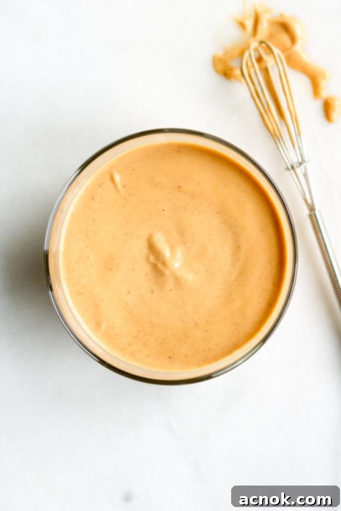 Creamy Golden Tahini Harissa Sauce in a small white bowl, ready to be served or used as a dip and dressing.