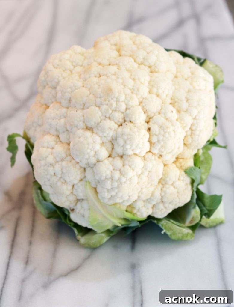 Whole head of fresh cauliflower on a cutting board