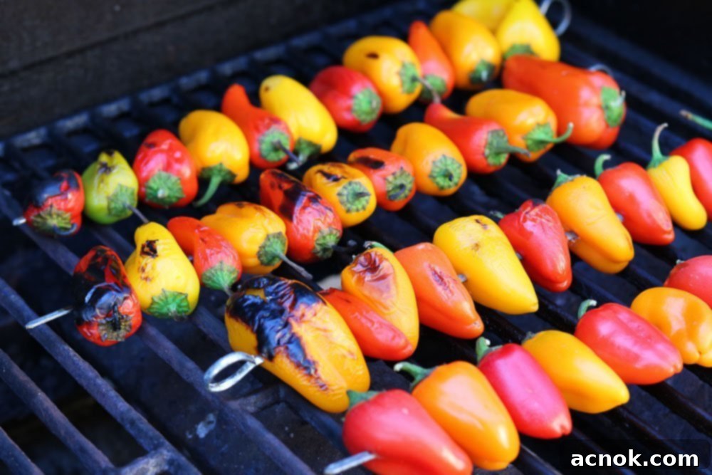 Grilled baby peppers cooling in a bowl, ready for dressing and mozzarella.