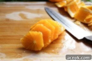 Bright, round orange slices neatly arranged on a cutting board, ready for the salad.