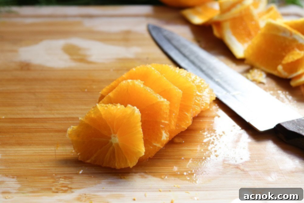 Neatly sliced orange rounds arranged on a cutting board, ready for salad assembly.