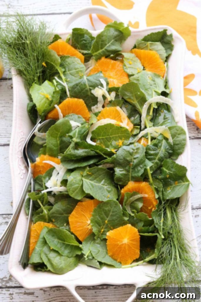 Beautifully assembled Orange Fennel Salad with fresh orange slices, baby kale, and thinly sliced fennel, lightly drizzled with dressing.