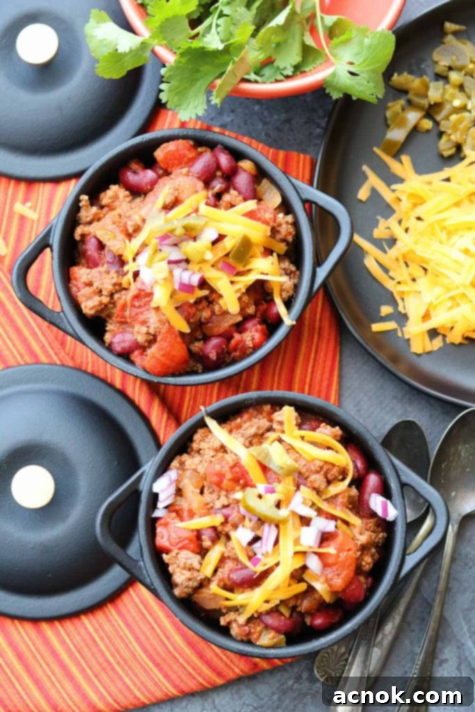 A bowl of comforting Fast and Easy Beef Chili, generously topped with shredded cheese, sour cream, and fresh cilantro, ready to be enjoyed